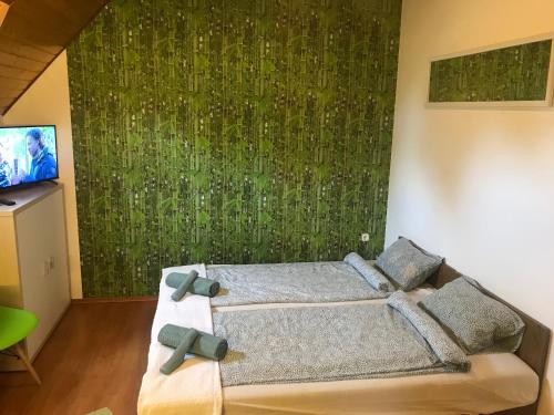a bedroom with a bed with a green wall at Balaton Garden in Balatongyörök