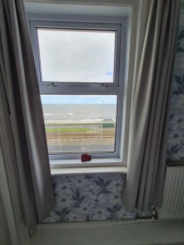 a window with a view of the beach at Queens Plaza Hotel in Blackpool