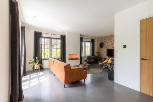 a living room with a couch and a chair at Casa Morreni, luxe villa met sauna in Voorthuizen