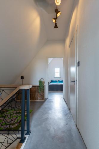 an attic hallway with a staircase leading to a bedroom at Casa Morreni Voorthuizen, luxe villa met sauna in Voorthuizen