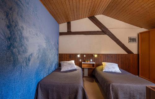 Pokój z 2 łóżkami i niebieską ścianą w obiekcie Hôtel-Résidence La Rubanerie w mieście Schirmeck
