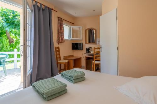 - une chambre avec un lit doté de 2 poufs verts dans l'établissement Auberge du Grand Chêne, à Sillans-la-Cascade