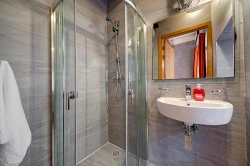 a bathroom with a sink and a glass shower at Tritoni Harbour suites - Valletta in Valletta
