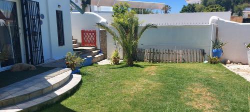 un patio con una valla y una palmera en Mi Cachito, en Los Caños de Meca