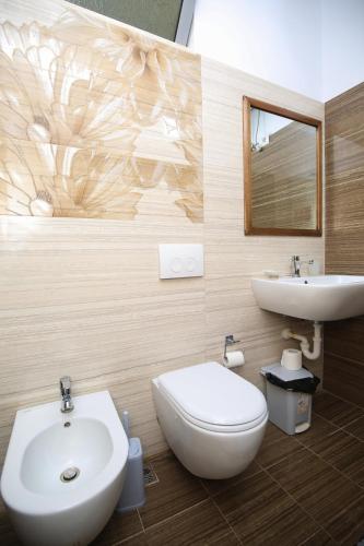 a bathroom with a white toilet and a sink at Hotel Summer Stars in Vlorë