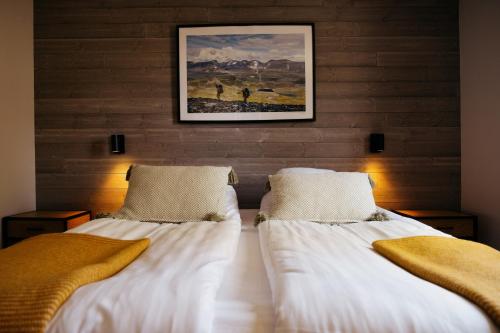 two beds in a room with a painting on the wall at Abisko Mountain Lodge in Abisko