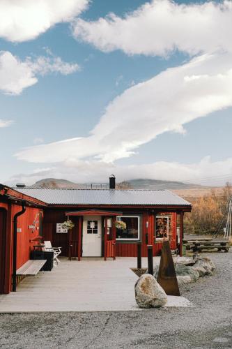 un piccolo edificio rosso con un patio di fronte di Abisko Mountain Lodge ad Abisko