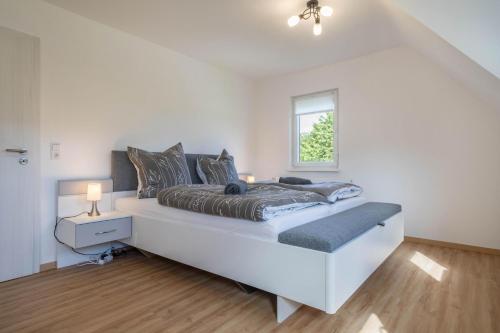 Un dormitorio blanco con una cama grande y una ventana en Ferienwohnung Schwarzwald Idyll en Glatten