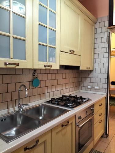a kitchen with a sink and a stove at Tettoeletto Garden Bio in Castellammare di Stabia