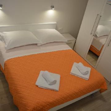ein Bett mit zwei weißen Handtüchern darüber in der Unterkunft Apartments Leon in Baška Voda