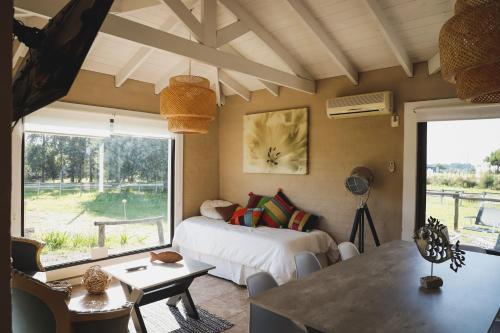 ein Schlafzimmer mit einem Bett und einem großen Fenster in der Unterkunft Finca Soñada in Colonia del Sacramento