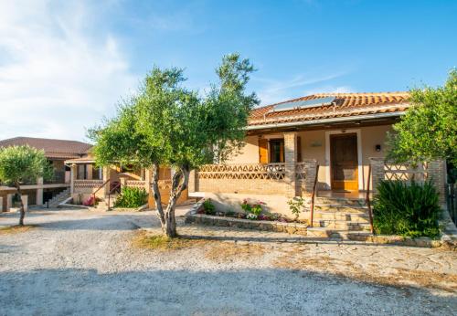 a house with a fence and trees in front of it at Aeolos Zante Villas with Heated Pool in Vasilikos
