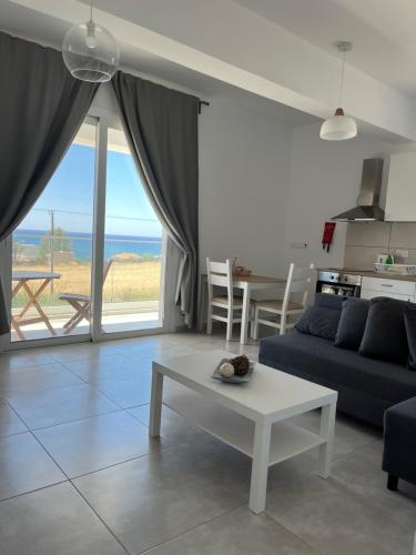 Blue Seaview Appartments في بافوس: غرفة معيشة مع أريكة وطاولة