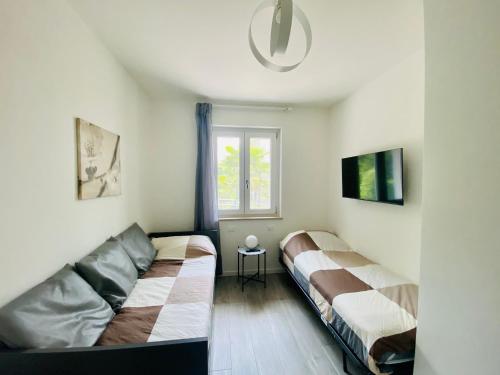 een woonkamer met 2 bedden en een raam bij C'era una volta Villaggio Ideal in Bardolino