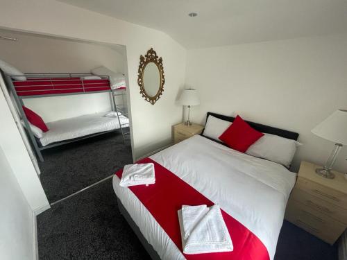 a bedroom with a red and white bed and a mirror at PCK THAS HOTEL in Blackpool