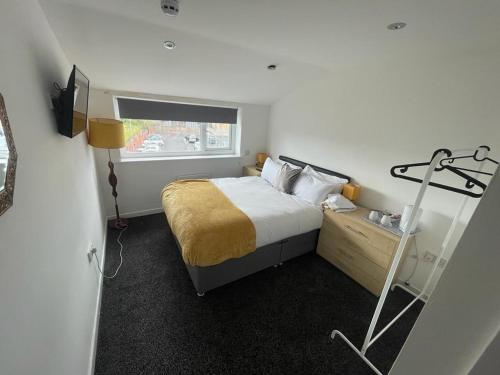 um pequeno quarto com uma cama e uma janela em PCK THAS HOTEL em Blackpool