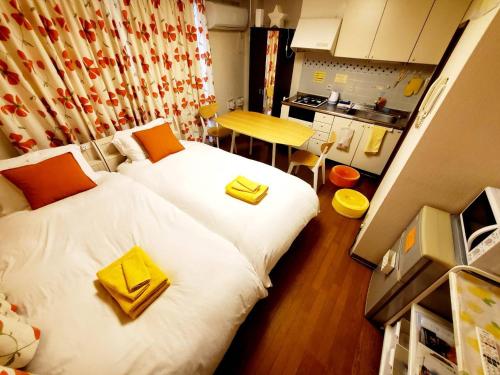 a small room with two beds and a kitchen at petit room201三宮10mim in Kobe