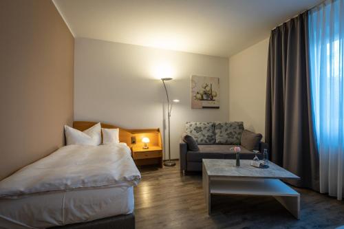 a hotel room with a bed and a couch at Hotel Pfälzer Hof GmbH in Braunschweig