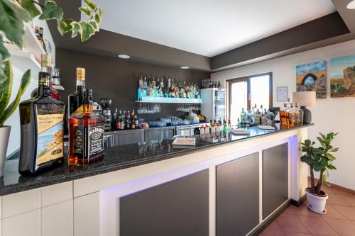 a bar with bottles of alcohol on a counter at La Terra Dei Sogni Country Hotel in Fiumefreddo di Sicilia
