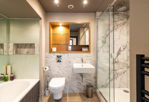 uma casa de banho com um lavatório, um WC e um chuveiro em The Lawrance Luxury Aparthotel - Harrogate em Harrogate