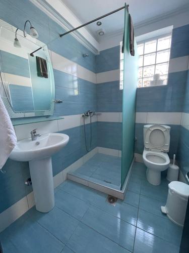 a blue bathroom with a sink and a toilet at Villa Elsa in Skala Rachoniou