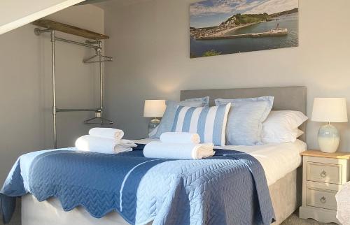 a bedroom with a bed with towels on it at Looe with a View - Entire apartment with FREE allocated parking in Looe