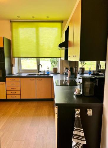 a kitchen with a black counter and a yellow window at R&M in Kortessem