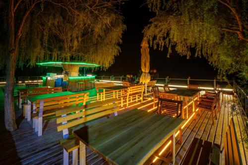 a wooden deck with benches and a fountain at night at Delta Boutique & Carmen Silva Resort in Crisan