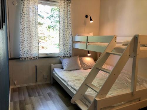 a bunk bed in a room with a window at Vandrarhem, Hostel in Hällestrand Semesterby in Strömstad