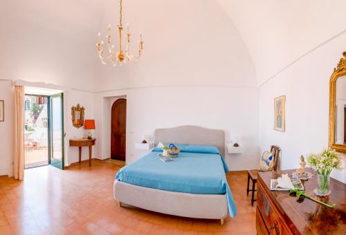 a bedroom with a bed and a table and a chandelier at Casa Lalù - Rustic apartment with stunning views in Positano