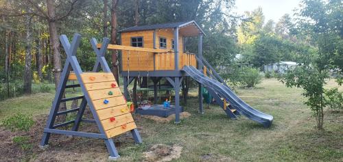 a playground with a tree house and a slide at Stacja Roztocze in Majdan Kasztelański