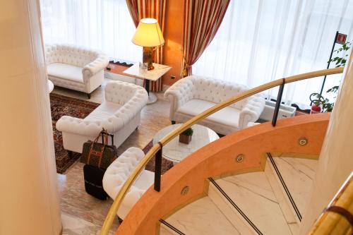 a living room with white furniture and a staircase at Hotel Giberti & Spa in Verona