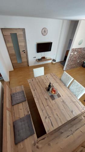 a living room with a wooden table and a flat screen tv at Apartments Ela in Rateče
