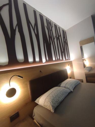 a bedroom with a bed with a large sign on the wall at Agritur Leita in Tuenno