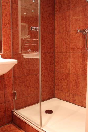 a shower with a glass door in a bathroom at Hotel Deutscher Kaiser in Nürnberg
