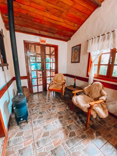 a living room with a wood stove and chairs at Pousada Mares do Santinho in Florianópolis