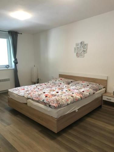 een slaapkamer met een groot bed met een sprei met bloemen bij Apartmán Plovárna in Kamenice nad Lipou