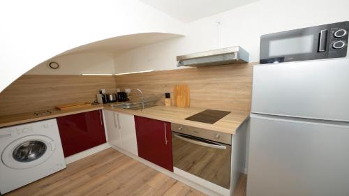 Il comprend une cuisine équipée d'un réfrigérateur blanc et d'un lave-linge. dans l'établissement Dominici 2- CahorsCityStay- Parking Wifi Netflix, à Cahors