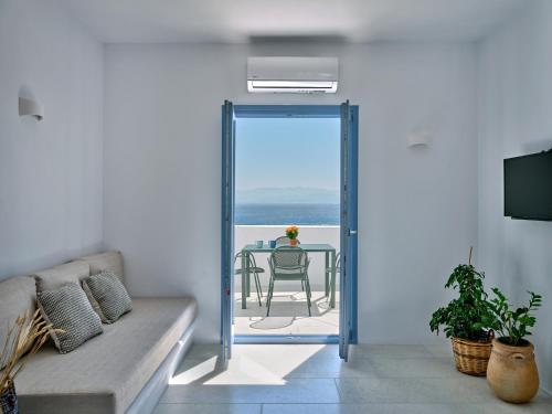a living room with a table and a view of the ocean at Etherio Apartment V in Piso Livadi