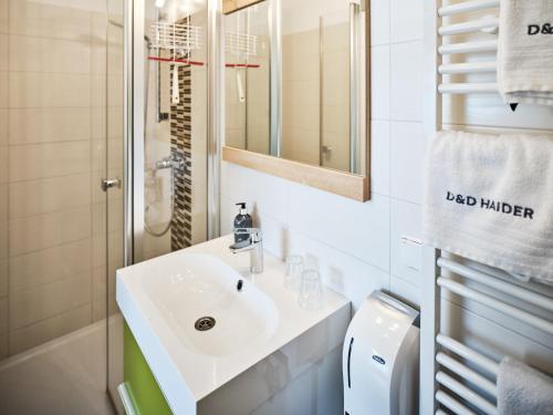 a white bathroom with a sink and a shower at Weingut Gästehaus D&D Haider in Jois