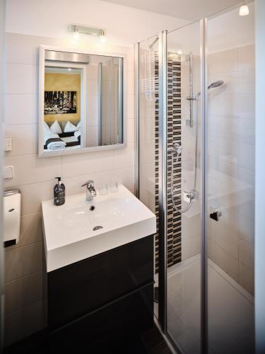 a white bathroom with a sink and a shower at Weingut Gästehaus D&D Haider in Jois