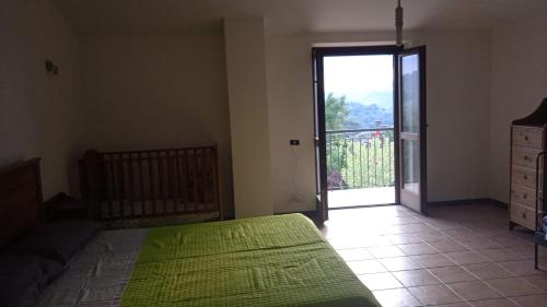 Casa vacanze ACQUAVIVA في Melizzano: غرفة نوم بسرير اخضر وباب زجاجي منزلق