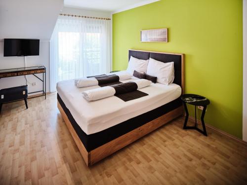a bedroom with a large bed with a green wall at Weingut Gästehaus D&D Haider in Jois