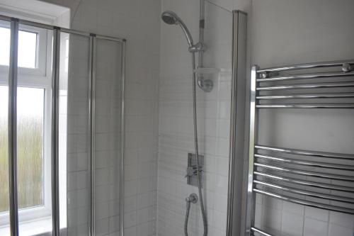 uma casa de banho com um chuveiro e uma porta de vidro em Starlight Cottage Room Only In Glastonbury em Glastonbury