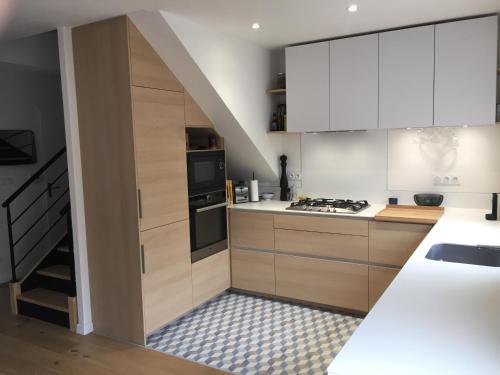 a kitchen with white cabinets and a staircase at Agréable maison neuve Angers Centre-Madeleine in Angers