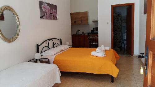ein Schlafzimmer mit zwei Betten und einem Spiegel in der Unterkunft Melia studio 2 seafront apartment in Loutráki
