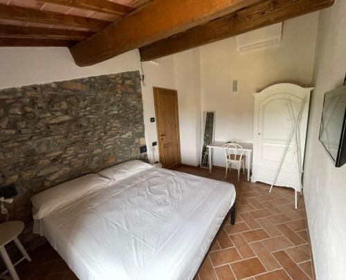 a bedroom with a bed and a stone wall at Affittacamere Il Vecchio Mandorlo in Montemagno