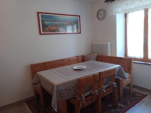 Serrada的住宿－Casa Ciclamino，用餐室配有桌椅和图片