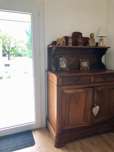 a wooden cabinet with clocks on it next to a door at Chambre particulière St Simon in Toulouse