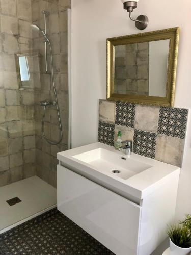 La salle de bains est pourvue d'un lavabo blanc et d'une douche. dans l'établissement Chambre particulière St Simon, à Toulouse